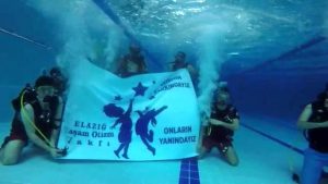 Su altında “Otizmin farkındayız, onların yanındayız” pankartı